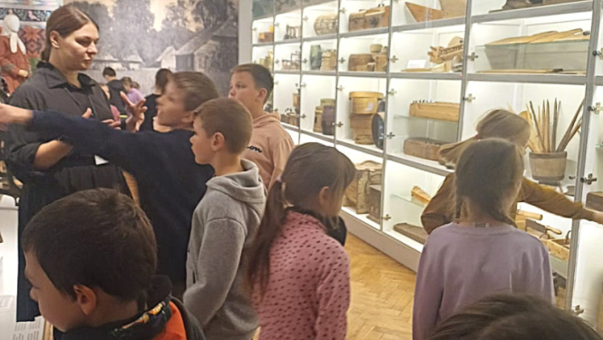 Bērni apskata muzeja eksponātus
