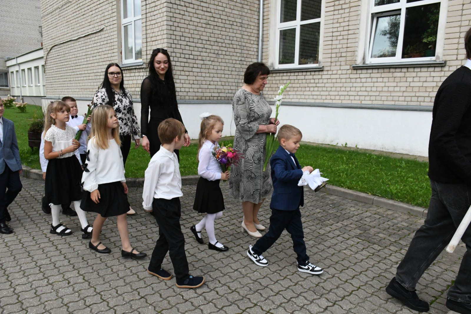 Jaunākie skolēni ar pedagogiem pie rokas
