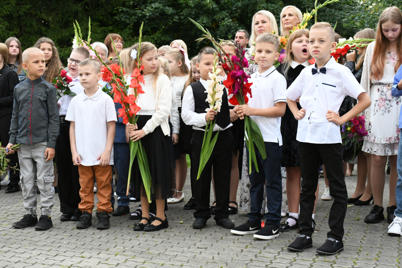 Skolēni ar ziediem, ko dāvinās skolotājām