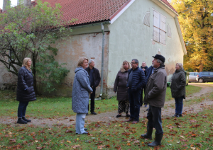 Imants pašvaldības pārstāvjiem stāsta par muižas parka celiņu