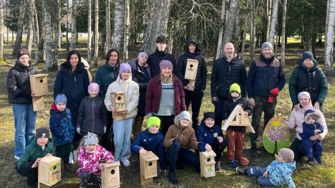 Pasākuma dalībnieki ar putnu būrīšiem