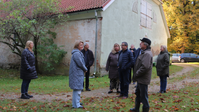 Imants pašvaldības pārstāvjiem stāsta par muižas parka celiņu