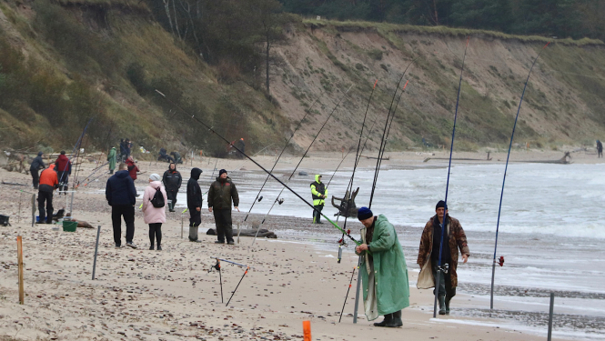 Pasākuma dalībnieki makšķerē no jūras krasta