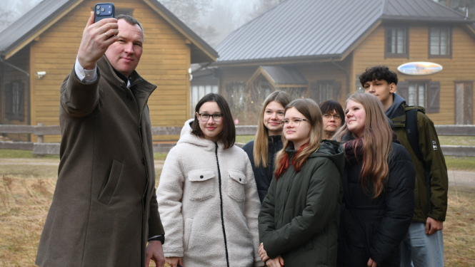 Priekšsēdētājs taisa fotogrāfiju ar jauniešiem