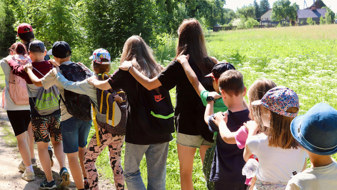 Bērni staigā rokas viens otram uzlikuši uz pleca