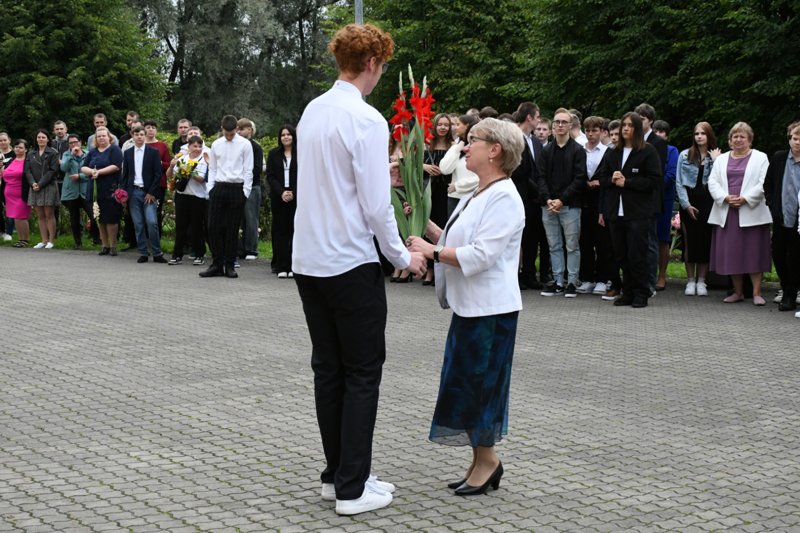 Skolēns pedagoģei dāvina ziedus