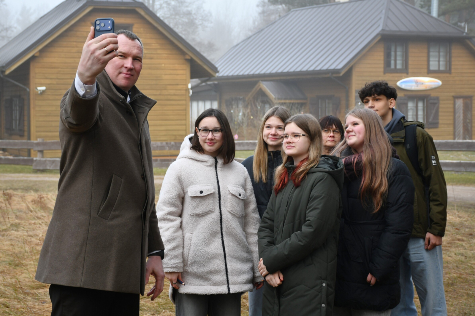 Priekšsēdētājs taisa fotogrāfiju ar jauniešiem