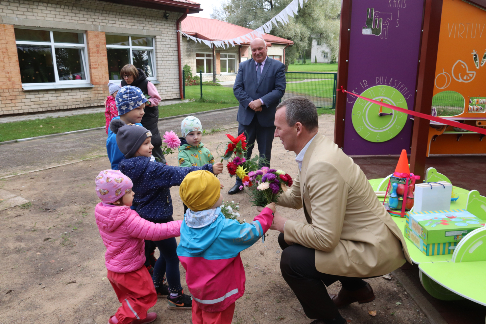 Bērni dāvina ziedus vadības pārstāvjiem