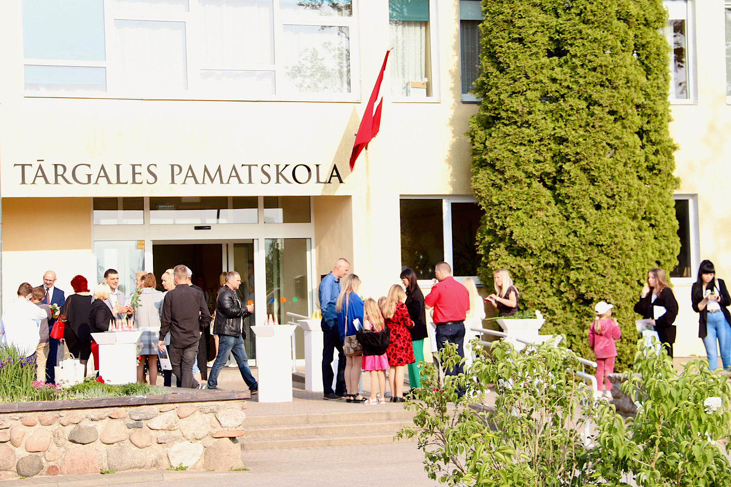Pasākuma apmeklētāji pie skolas