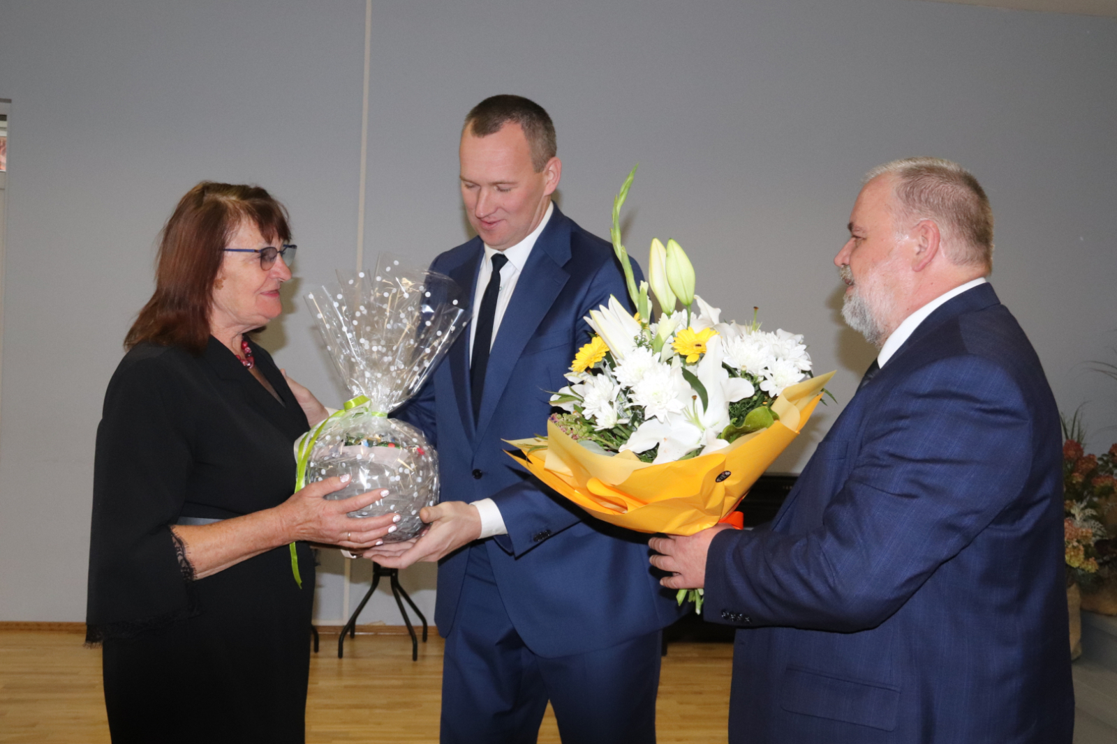 Priekšsēdētājs un viņa pirmais vietnieks sveic folkloras kopas vadītāju Ligitu Lukševicu