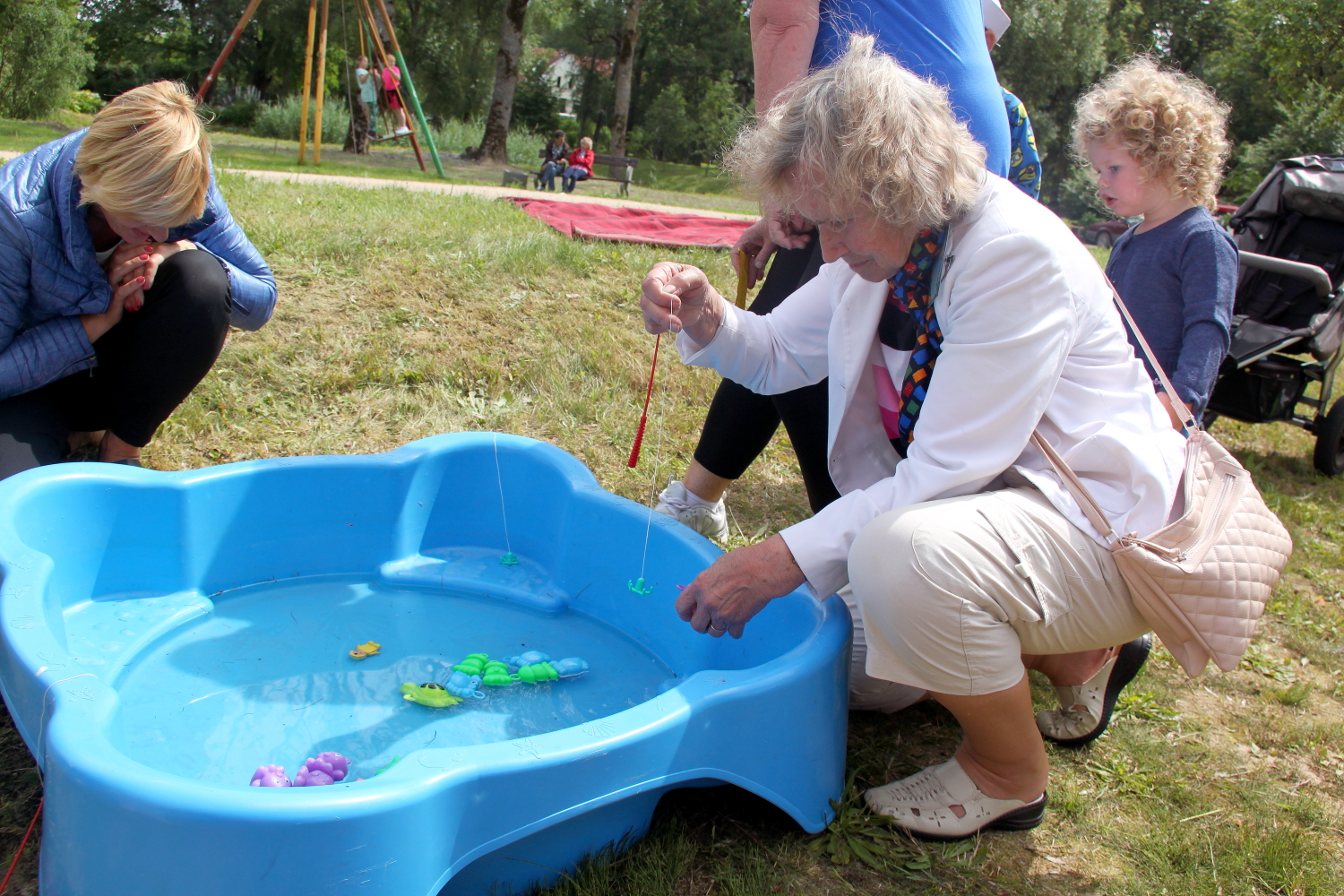 Seniori makšķerē zivtiņas no baseina