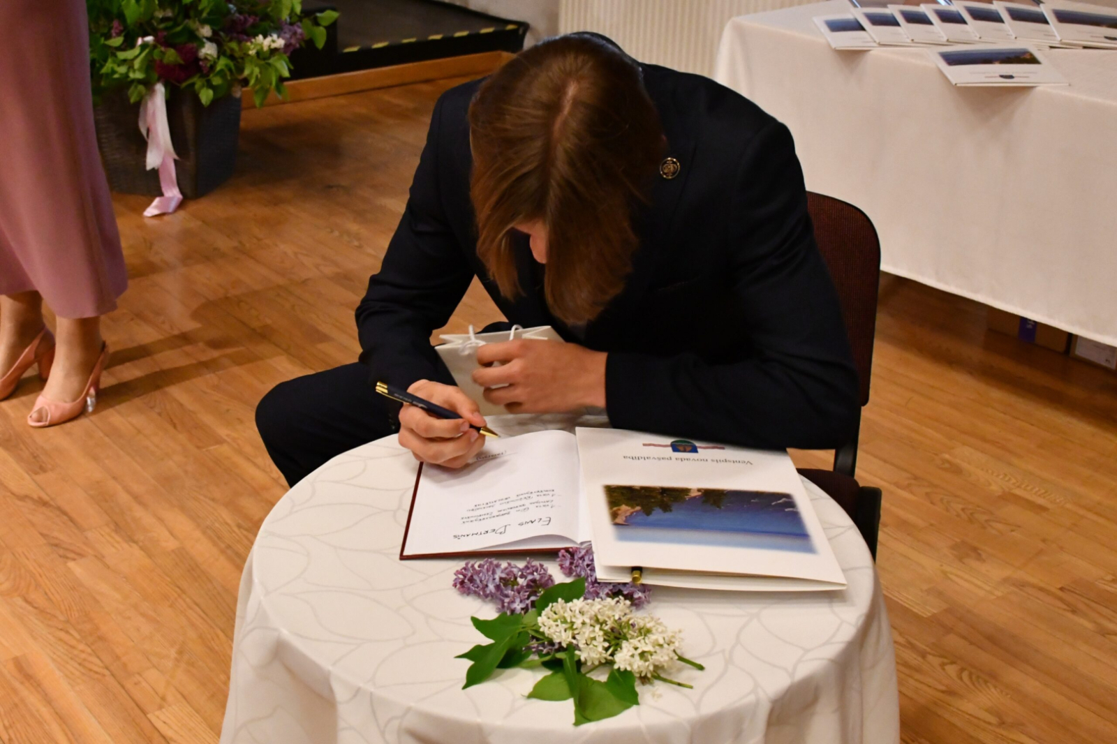 Skolēns parakstās grāmatā